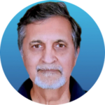 Portrait of an older man with gray hair, a short gray beard and mustache, wearing a dark shirt, shown against a blue gradient background.