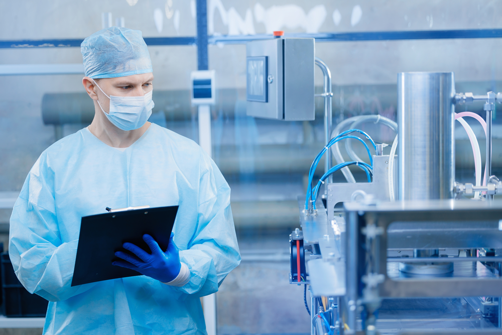 Person in protective gear inspecting equipment with a clipboard